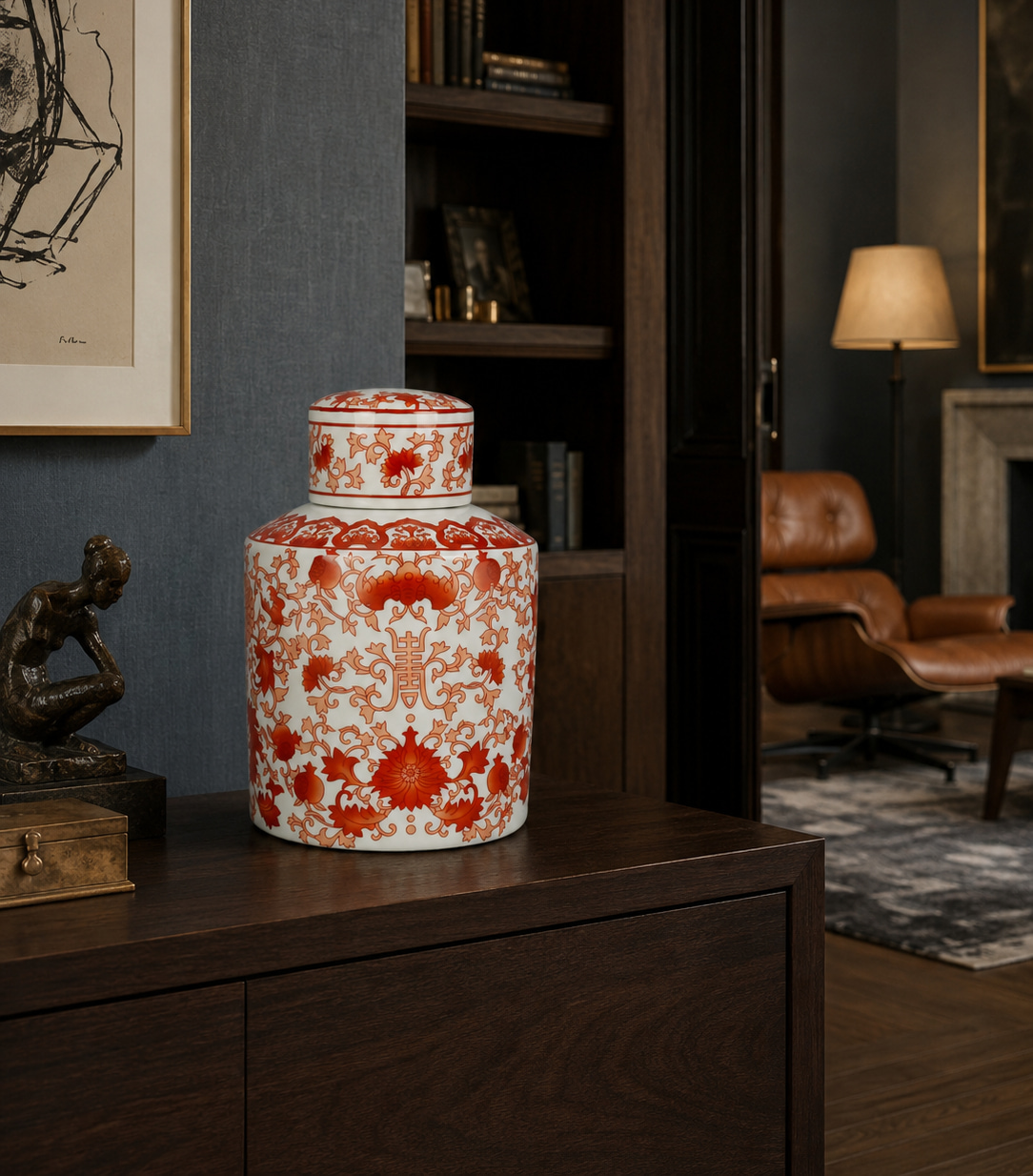 Decorative white porcelain jar with red floral pattern on a dark wooden cabinet in a living room.